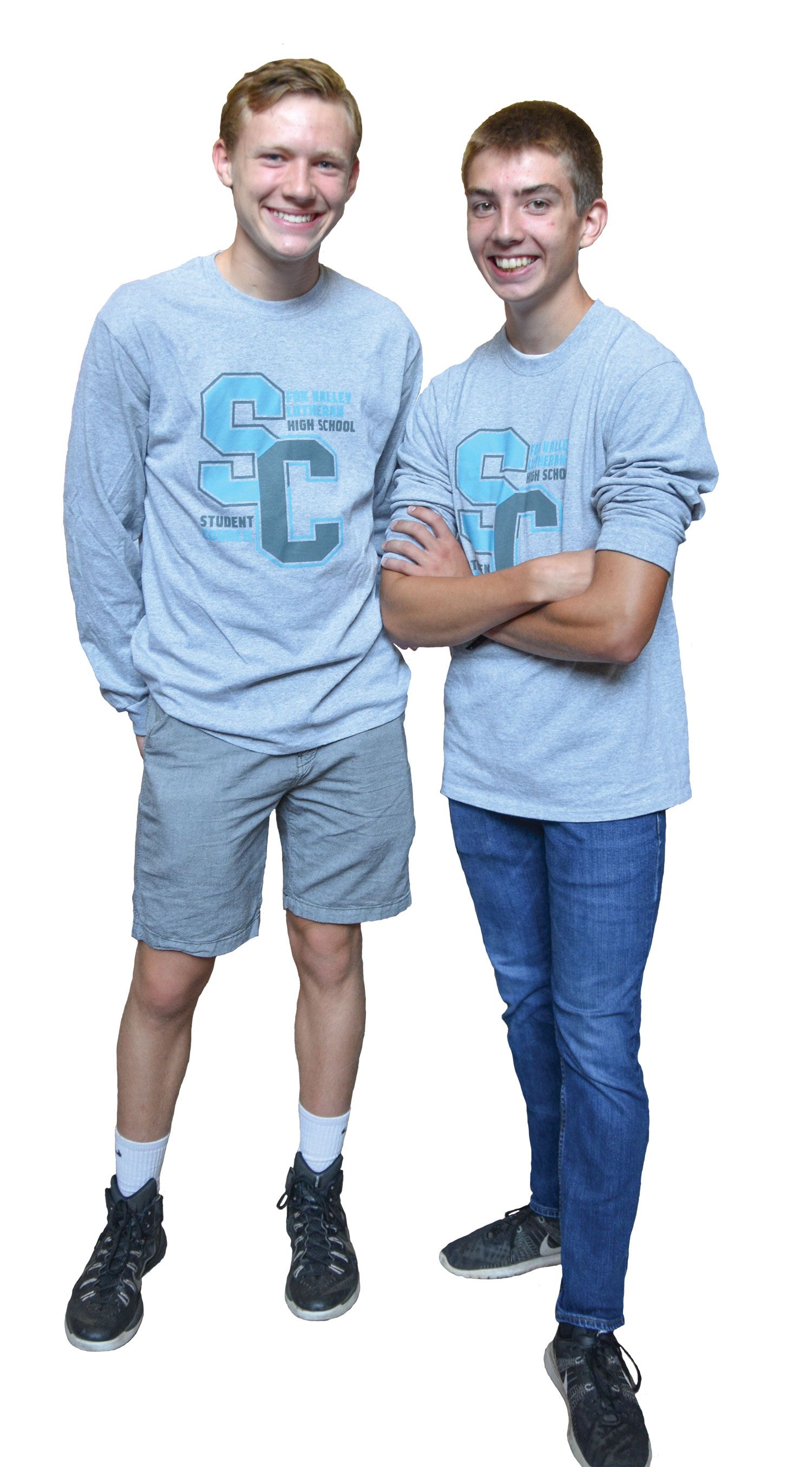 Two guys, standing, smiling, and looking at the camera