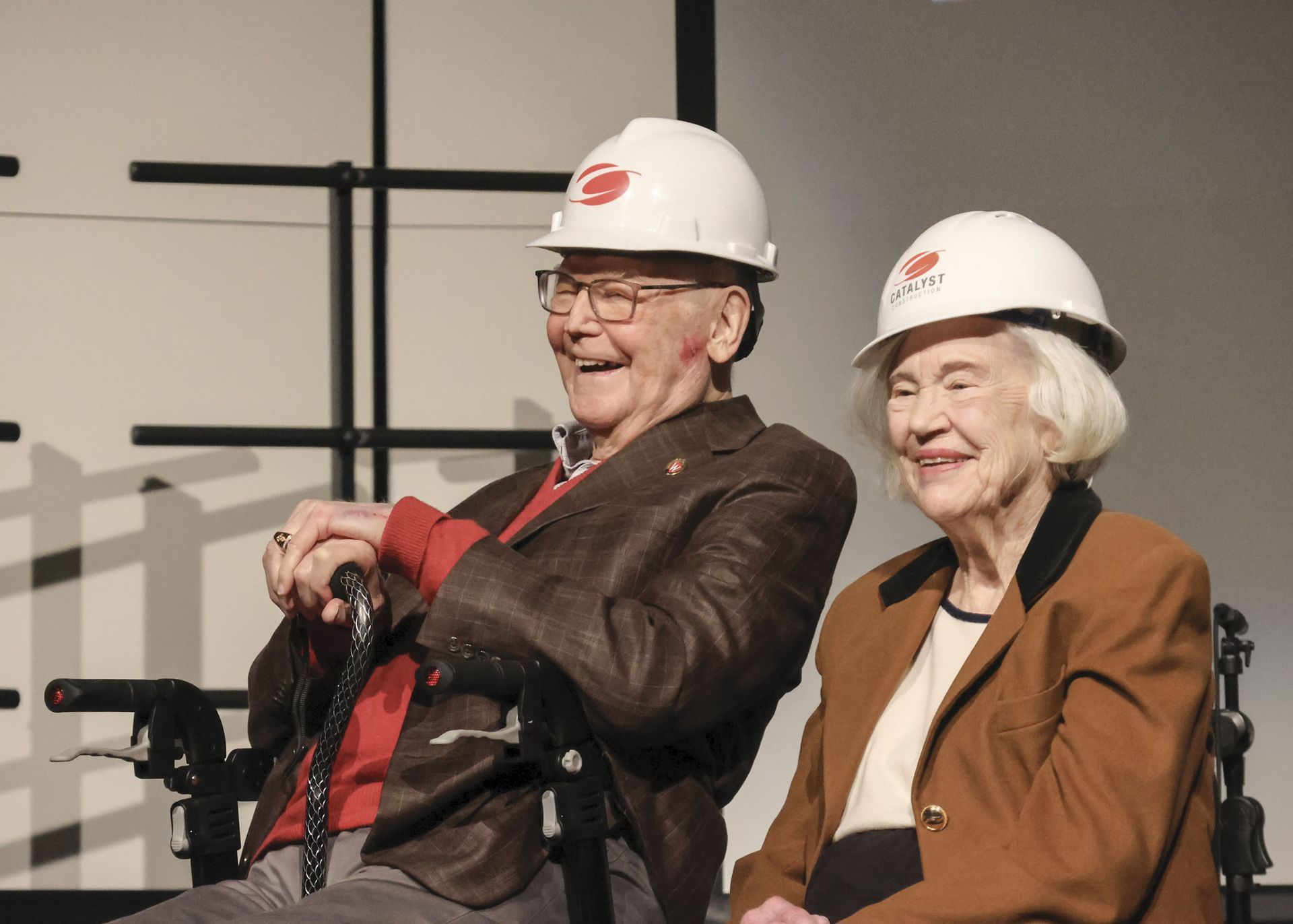 Dr. and Mrs. Monroe Trout smiling, and wearing hard hats at the Groundbreaking ceremony