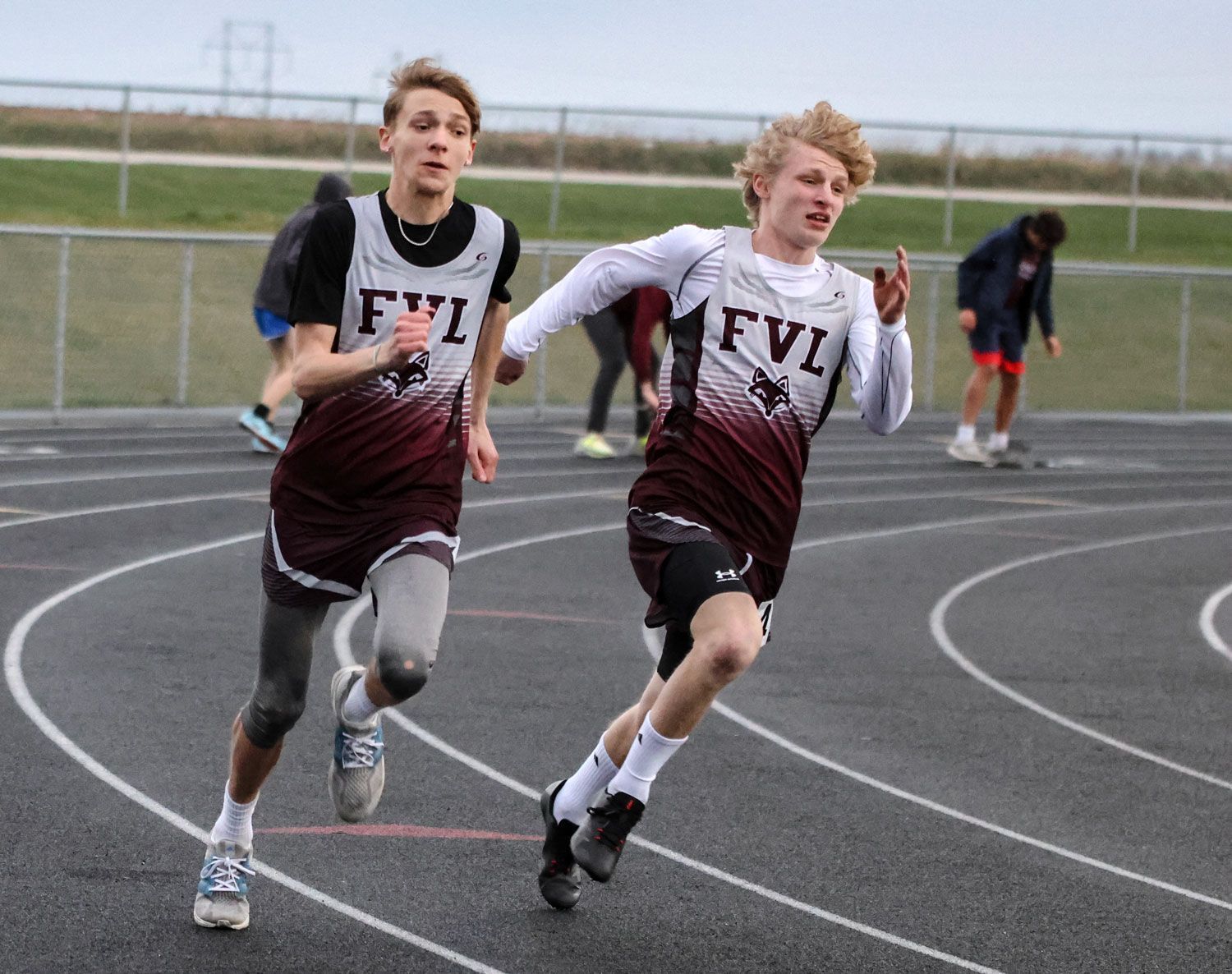 Two male FVL track members, running a race