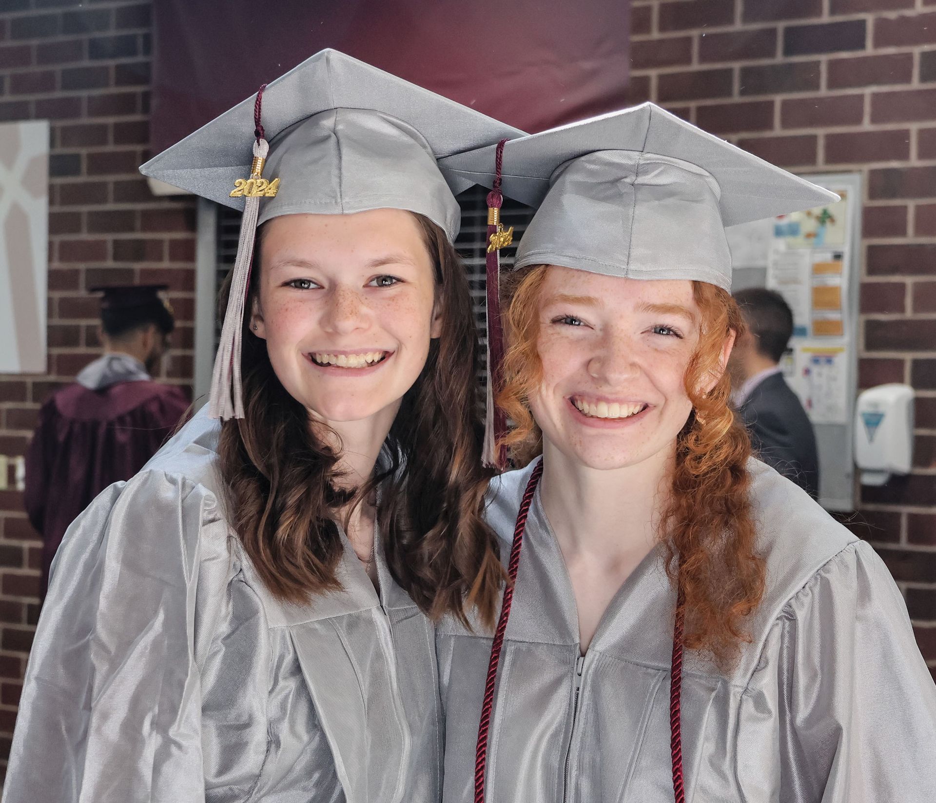 Two female graduates smiling and looking at the camera