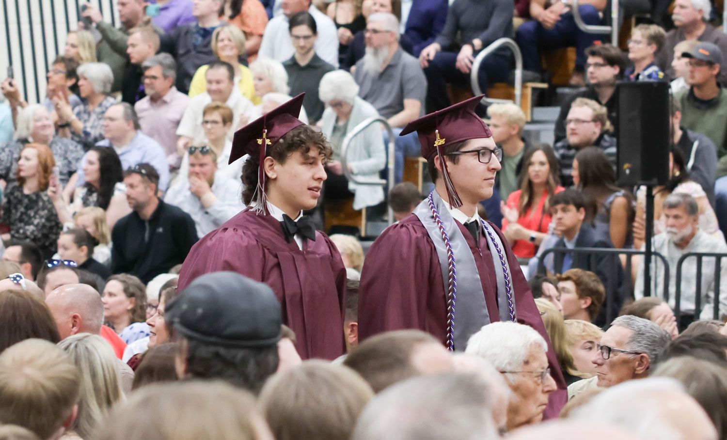 Two male students walking down the aisle during processional