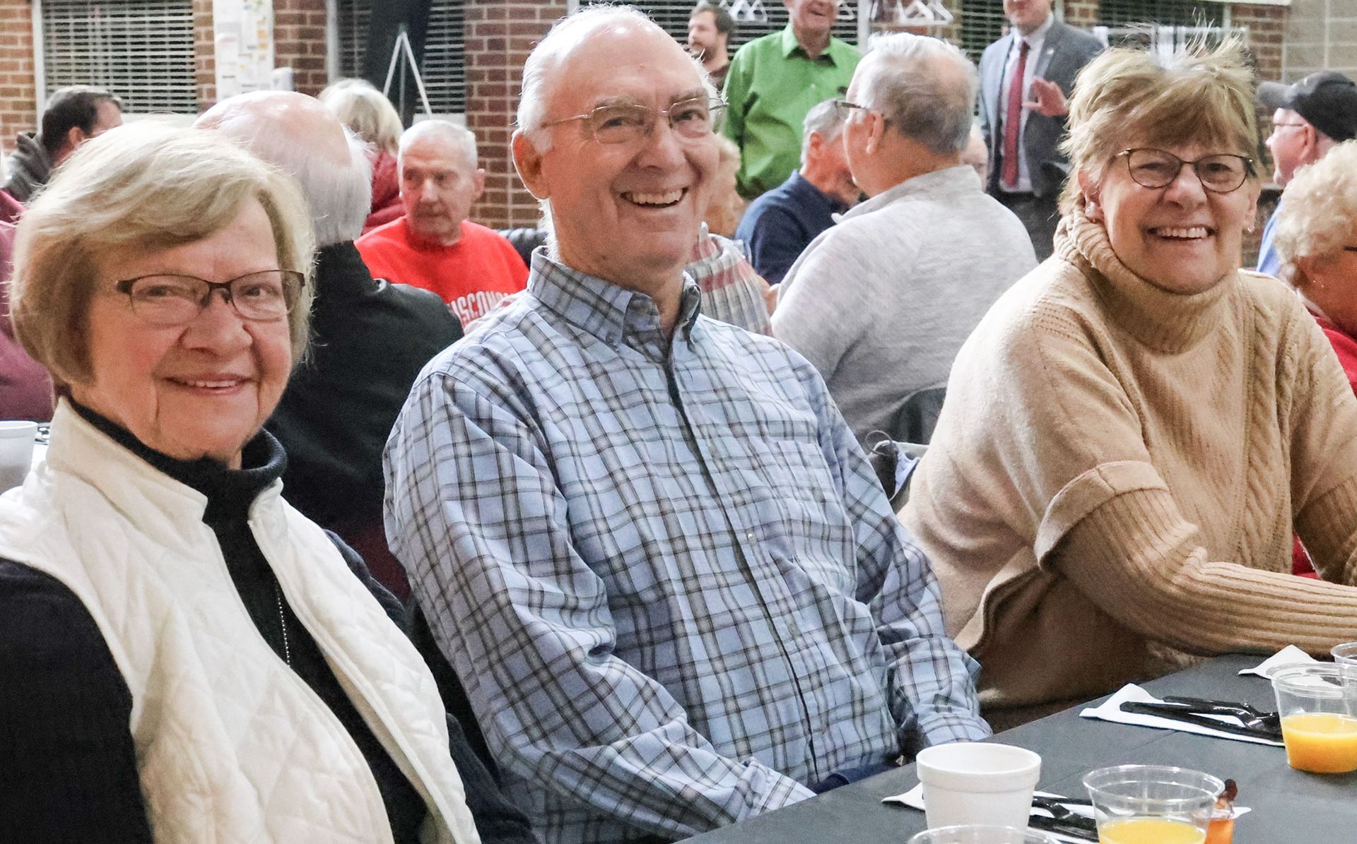Three smiling attendees sitting at the table during the Veterans Day breakfast