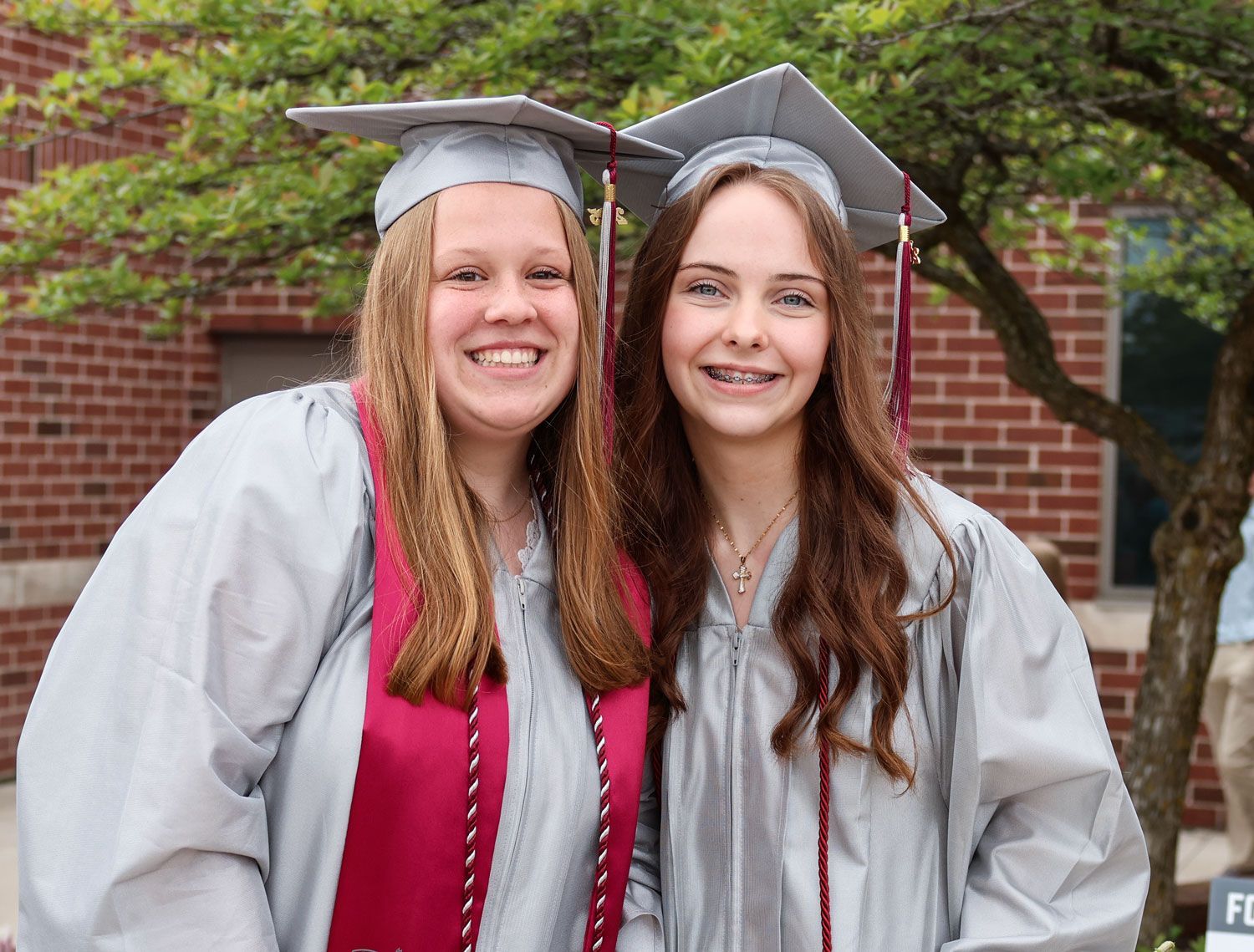 Two happy female grads, outside, after ceremony