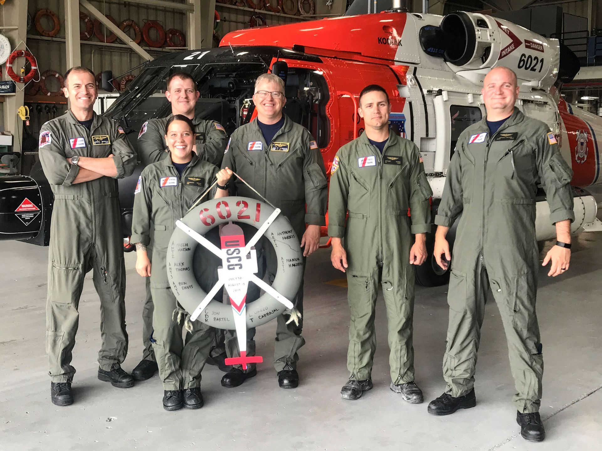 Six Coast Guard crew (including Jon Bartel) standing in front of a Coast Guard helicopter