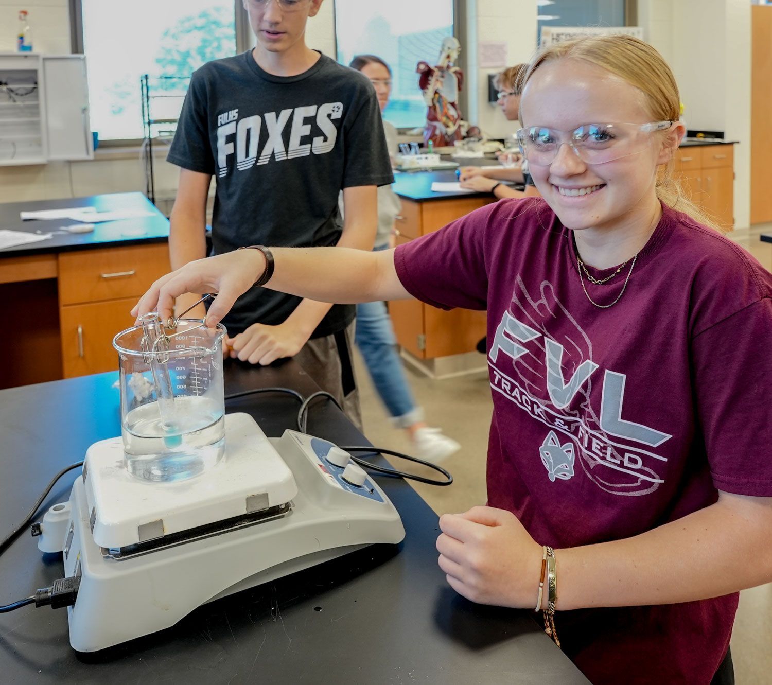 Smiling female student in science lab, conducting an experiment