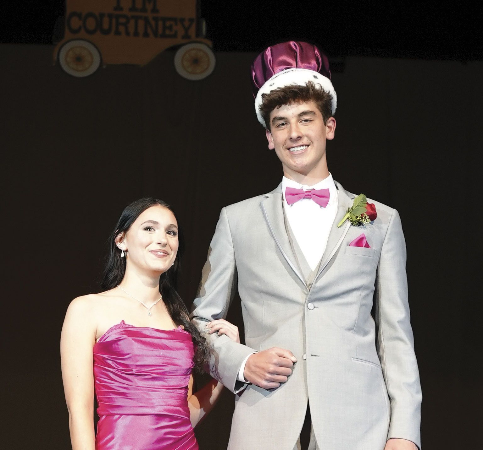 Smiling prom king (wearing his crown) and queen