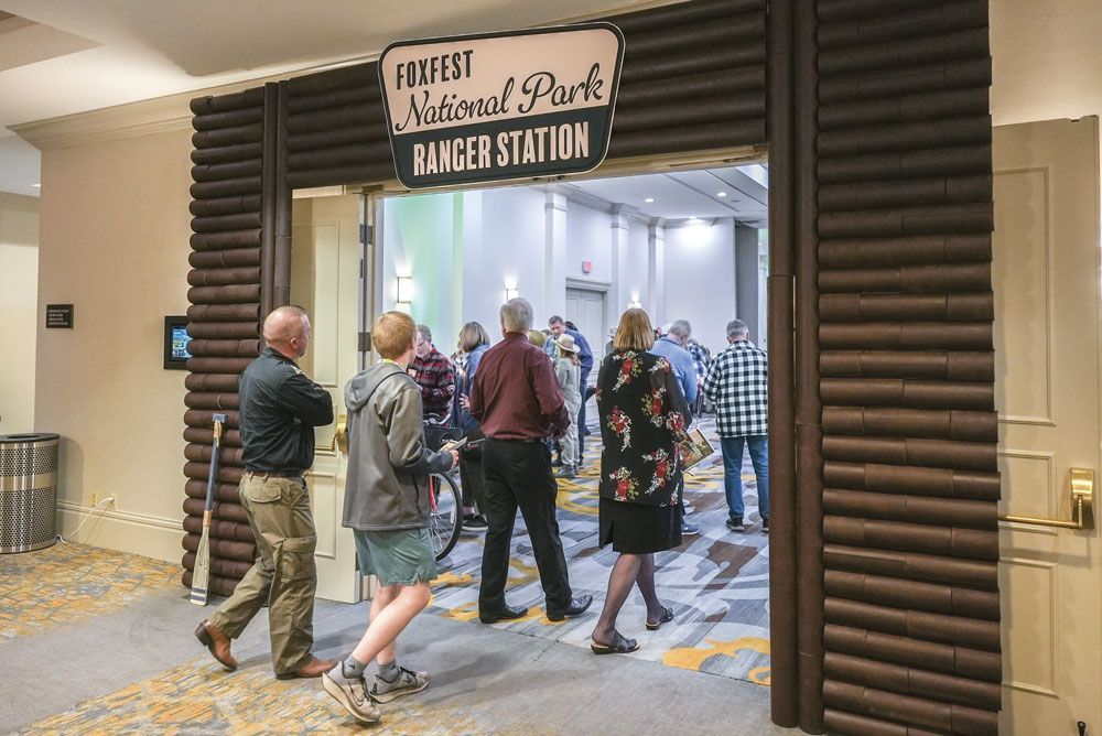 People walking through the doorway to FoxFest. The doorway looks like a ranger station