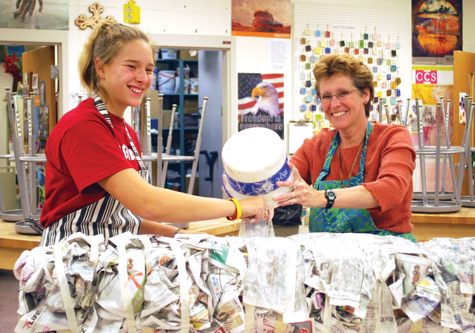 Mrs. Schlawin and female student working on paper mache project