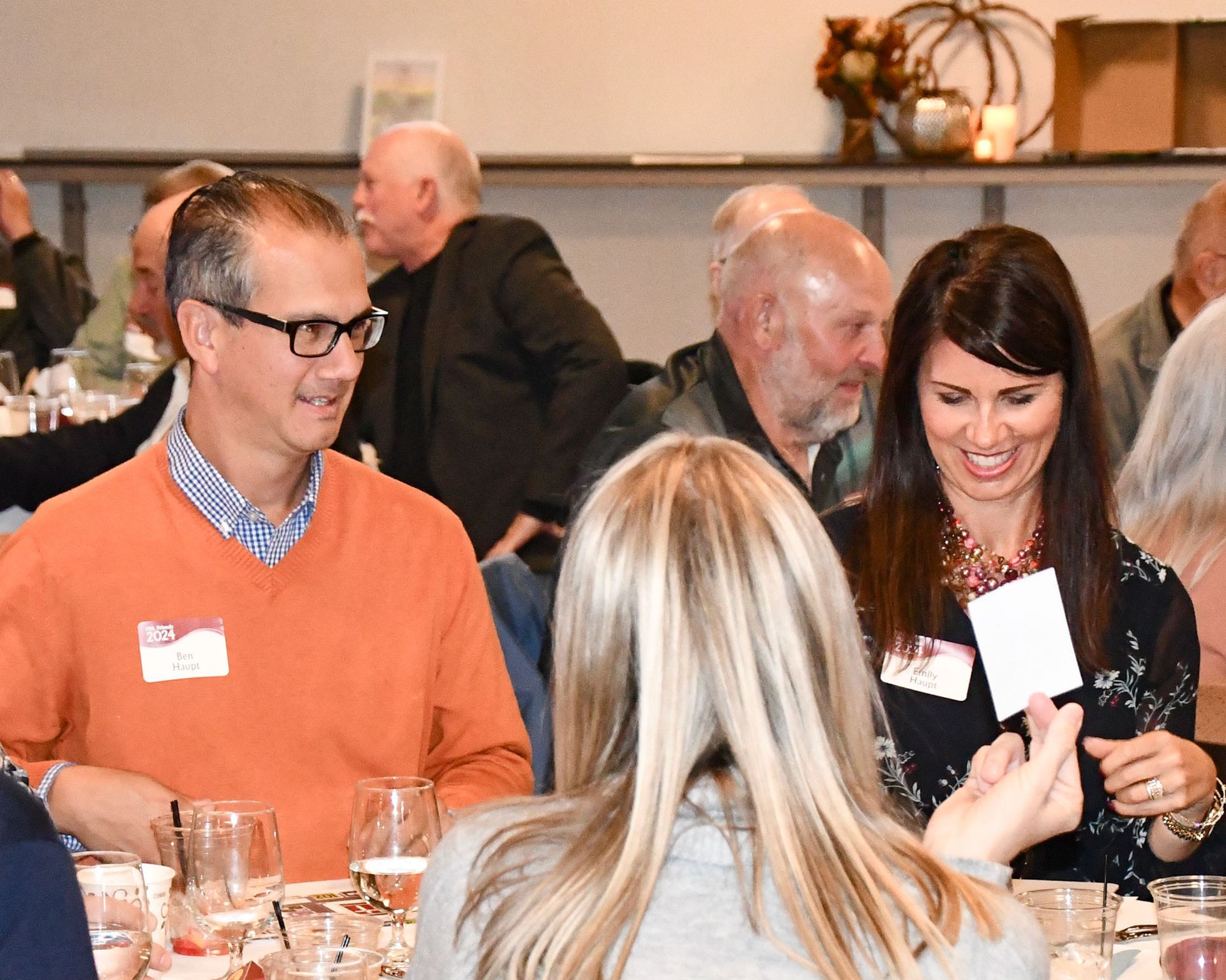 Three women in lively conversation while standing by a table