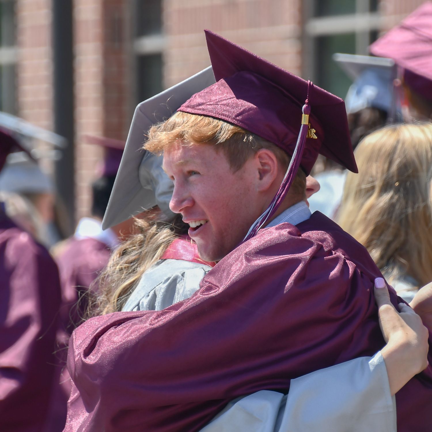 A guy and a girl hugging, outside after the ceremony