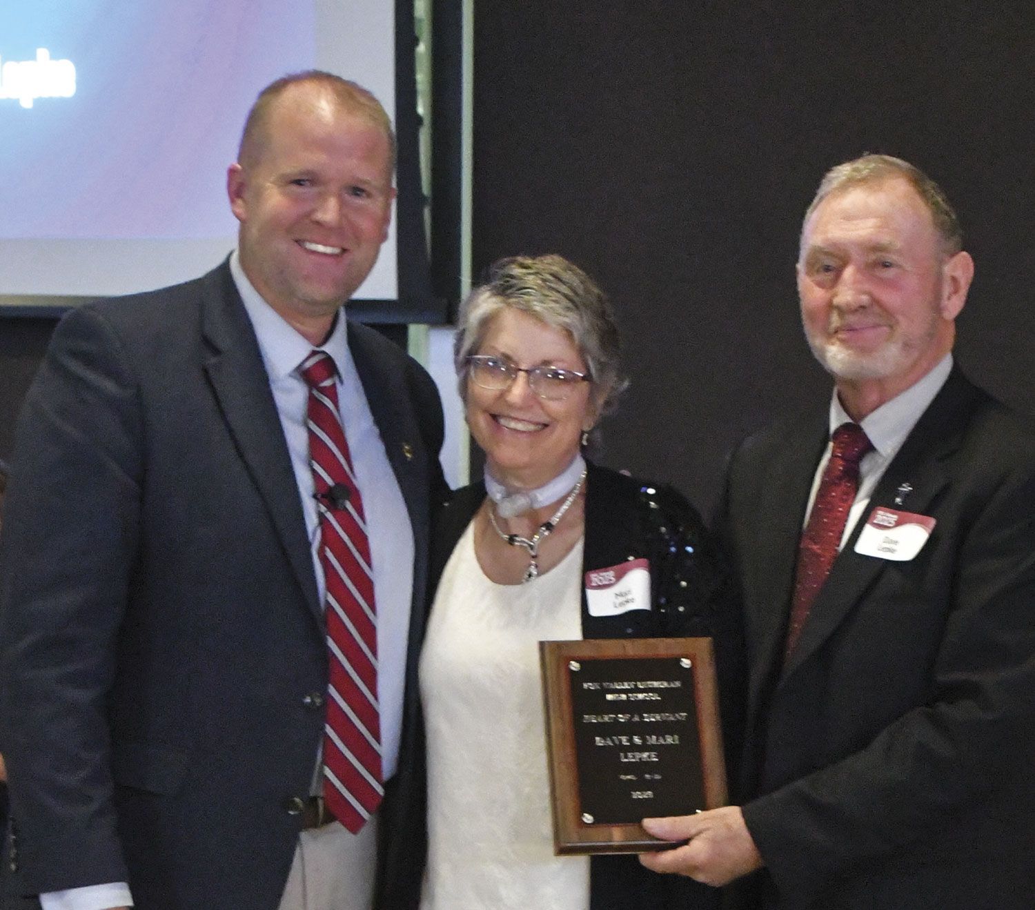 President Loberger with Mari and Dave Lepke, who are holding up their Heart of a Servant plaque