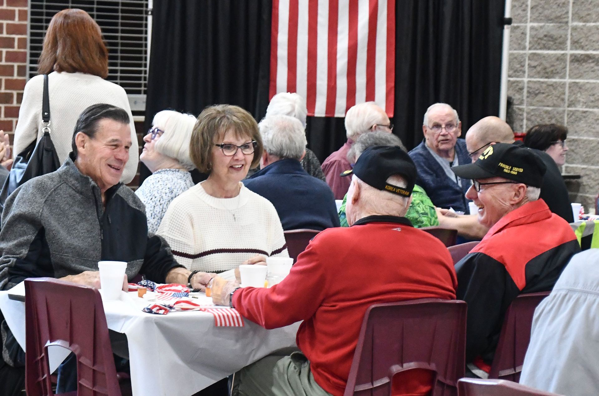 Three smiling attendees sitting at the table during the Veterans Day breakfast