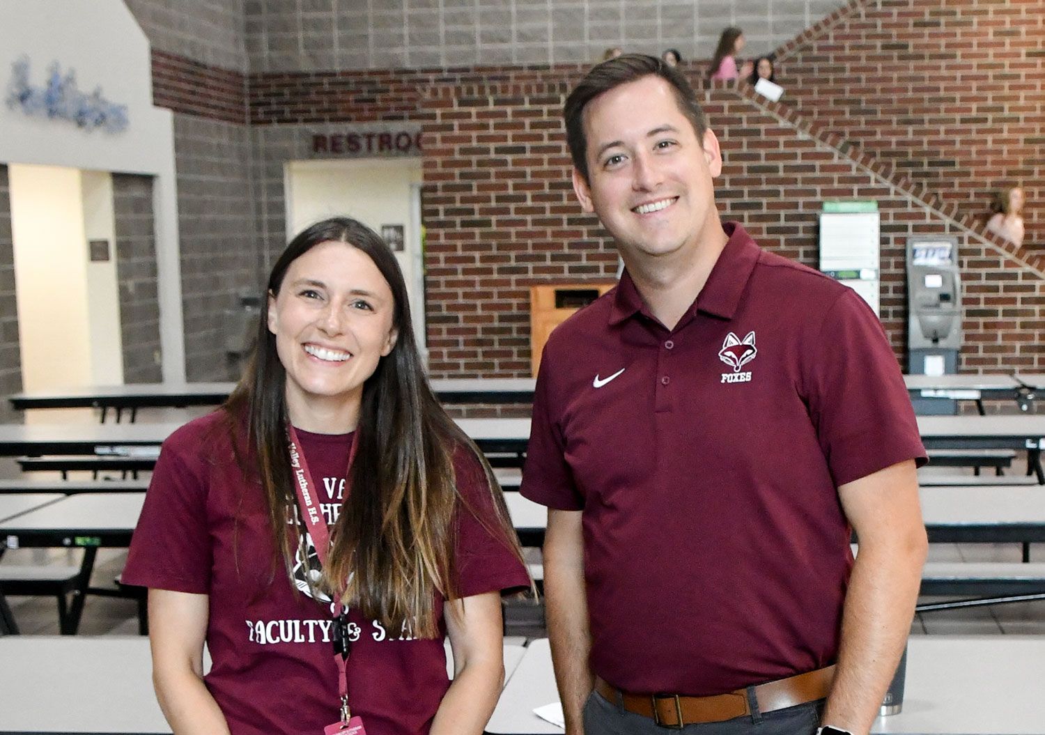 Male and female FVL teachers in Commons, smiling at the camera