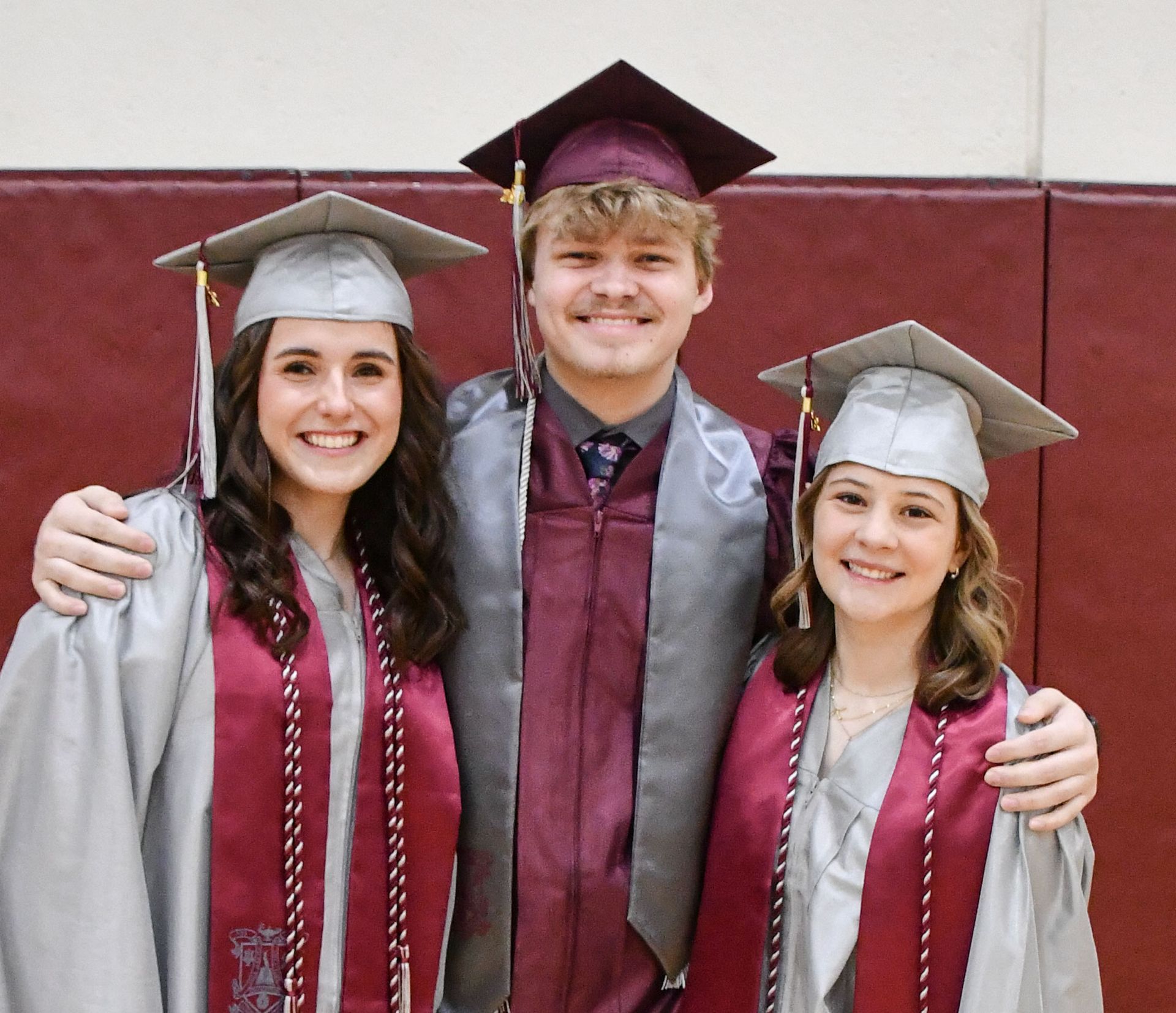 Two girls and one guy, smiling, prior to ceremony