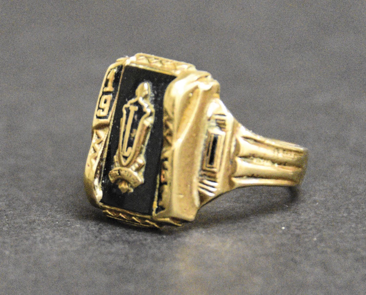 Closeup of men's FVL class ring from 1963. It is gold with black accents.