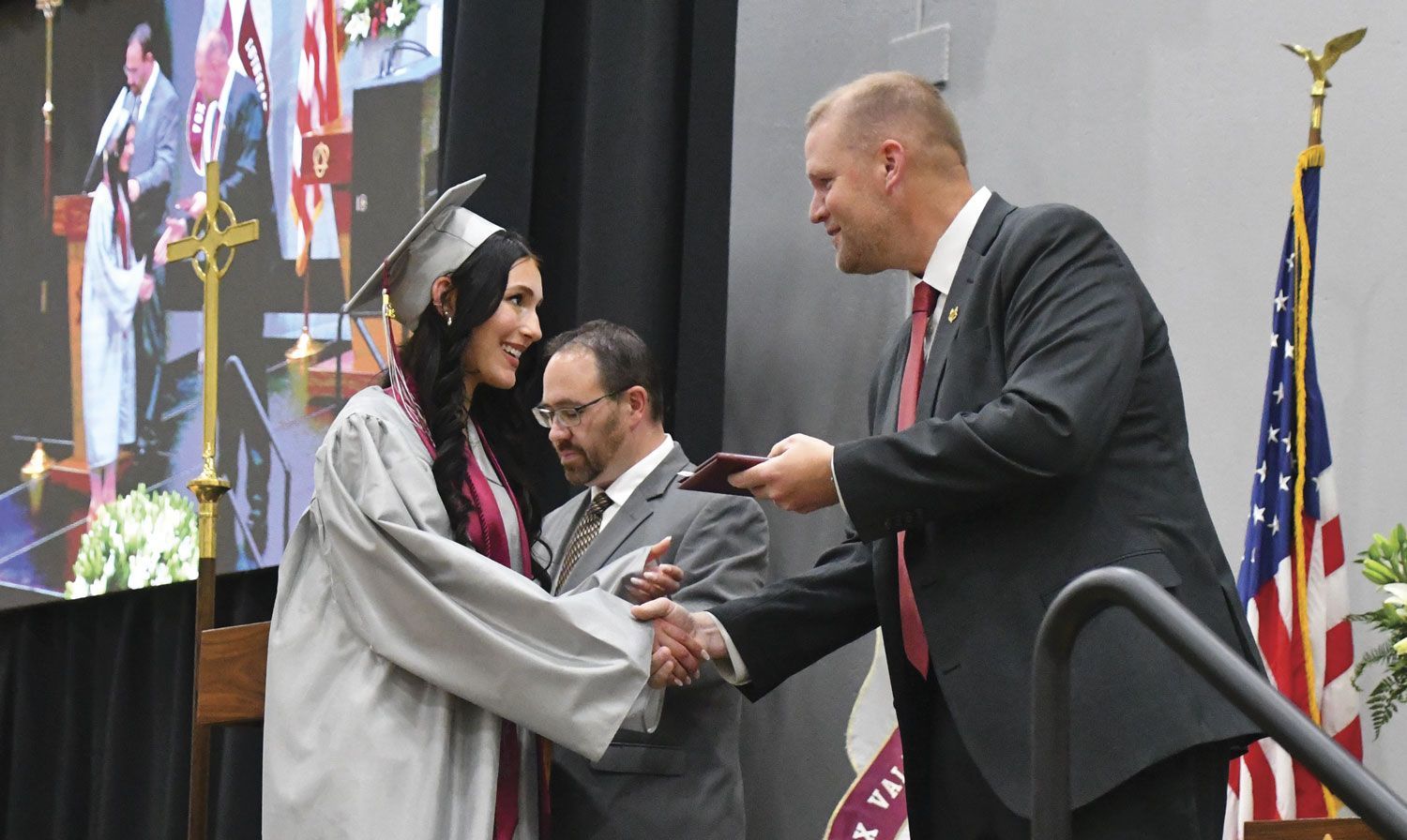 Female student receiving diploma from President Loberger