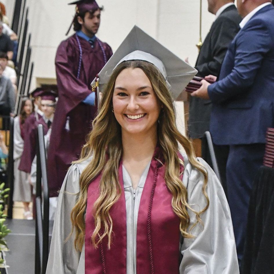 Smiling female graduate just stepped off the stage after receiving diploma