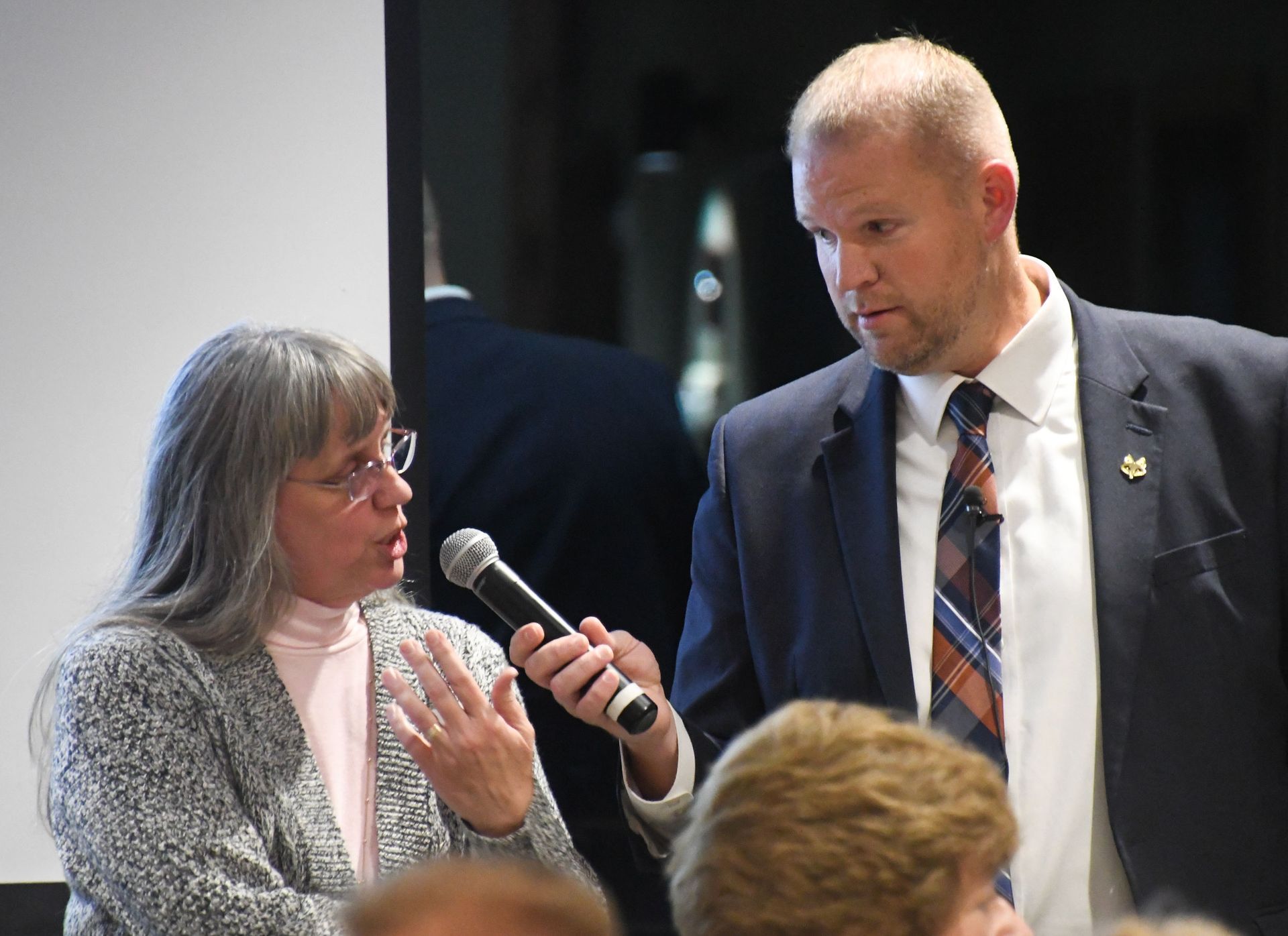 President Loberger with a microphone held out to a female attendee