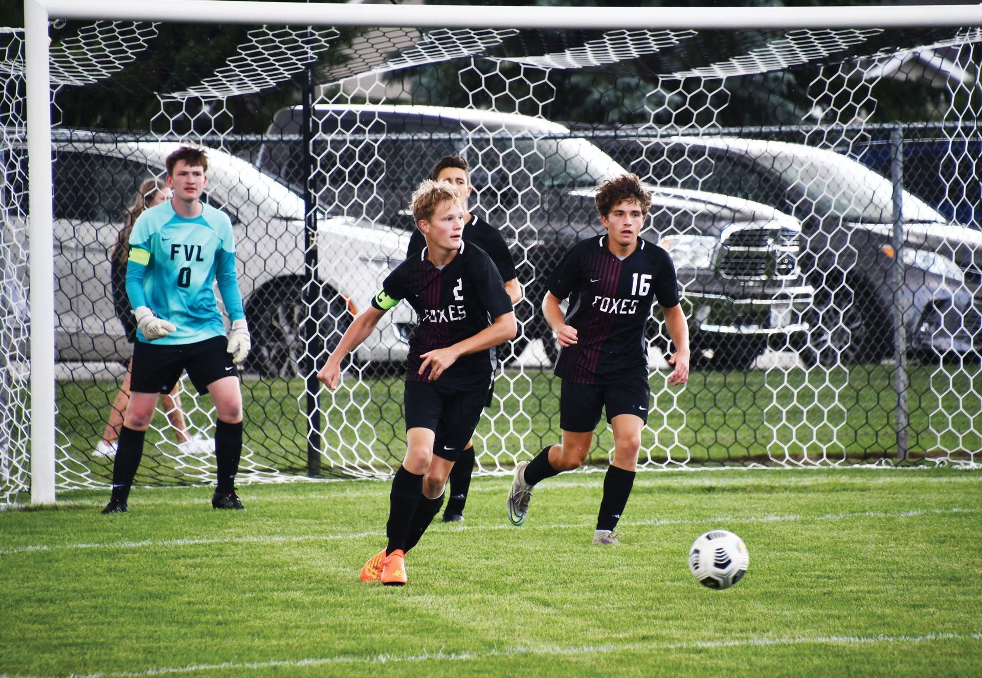Soccer players running after the ball