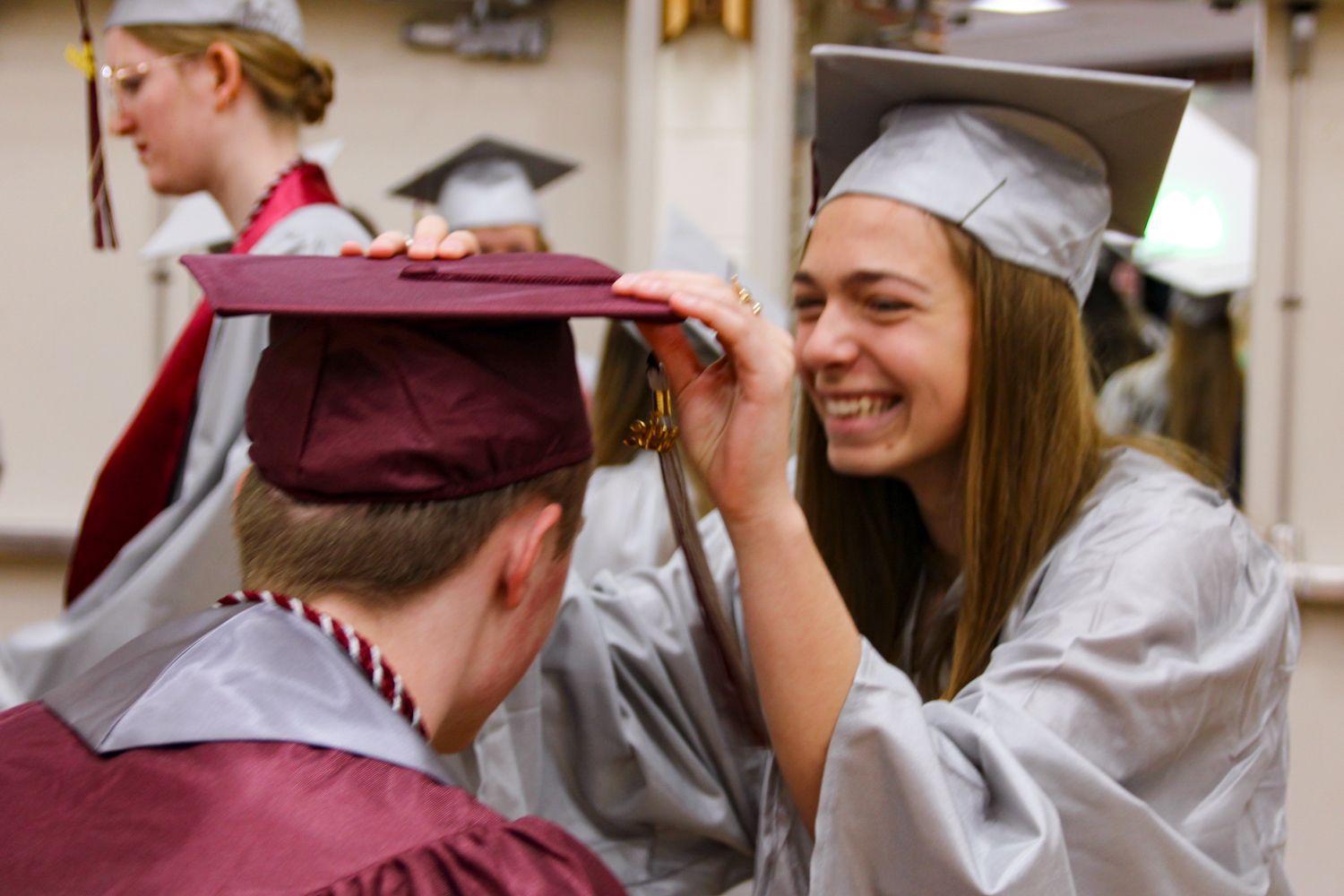 Girl helping a guy with his cap