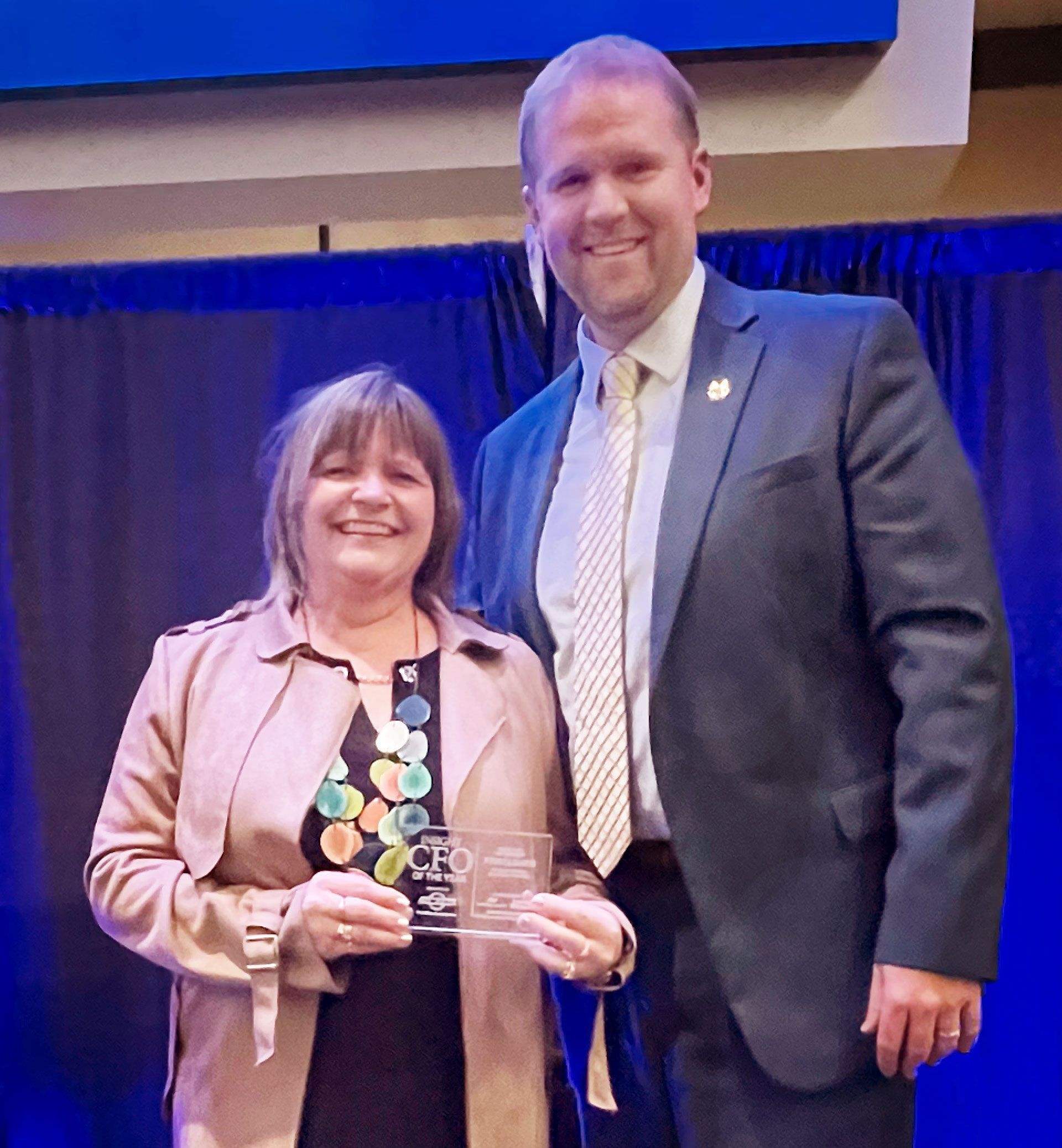 Krista Davis holding her award and standing next to Jeff Loberger