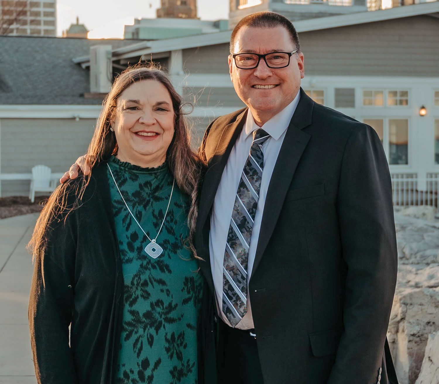 James and wife Julie, outside in golden light, smiling at the camera