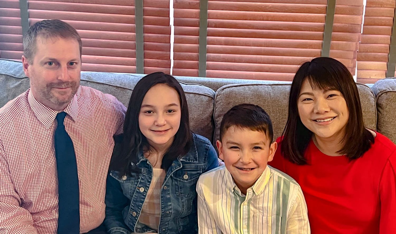 Shawn and his family on a sofa. Shawn is on the left, then his daughter, his son, and his wife