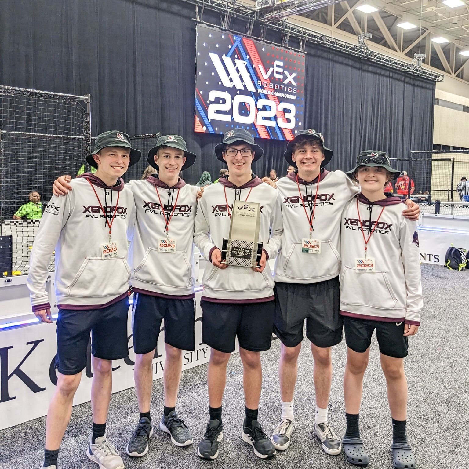Five members of the VEX team, holding their trophy