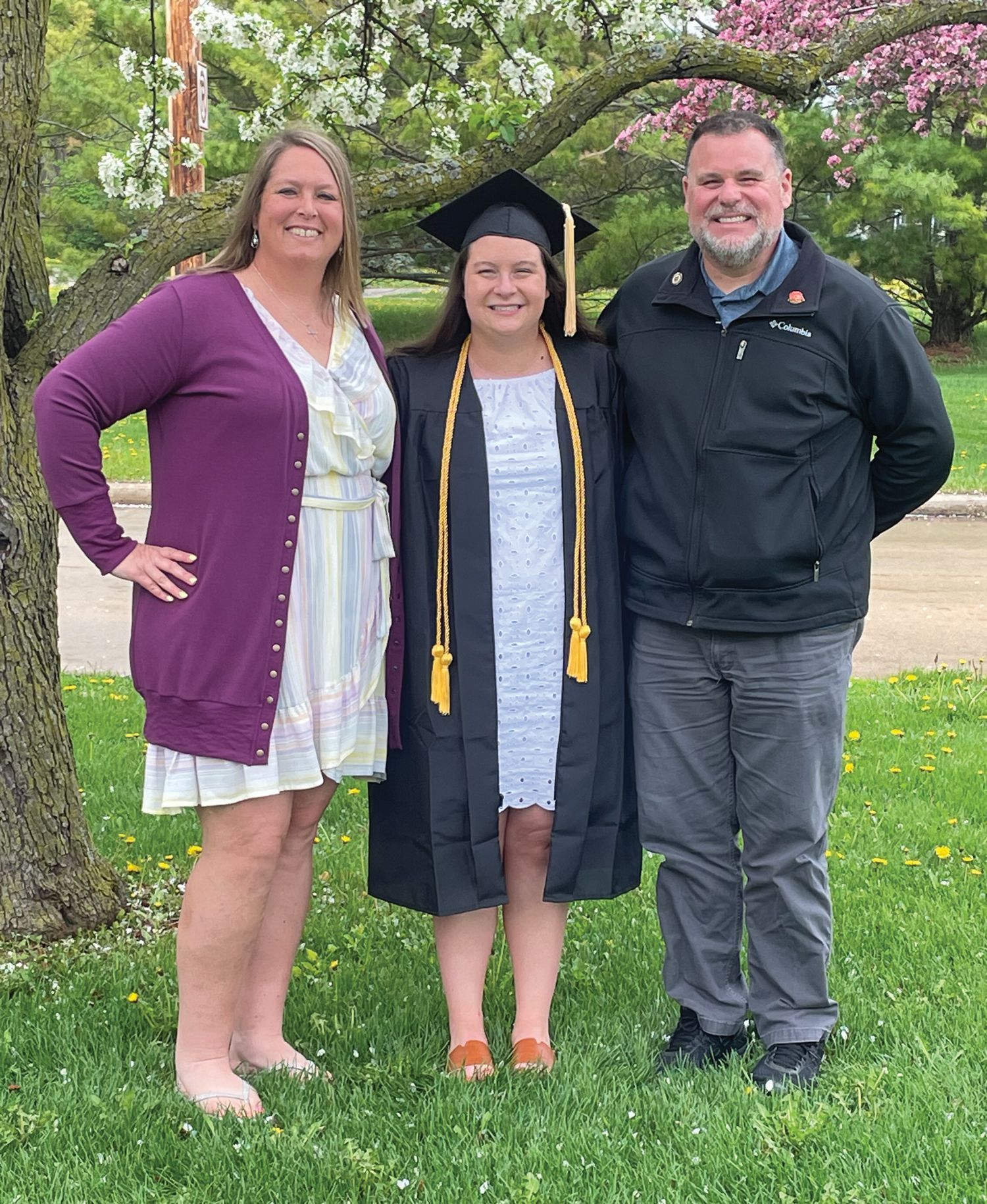 Anne Wilson with her husband and their daughter. The daughter is in a cap and gown