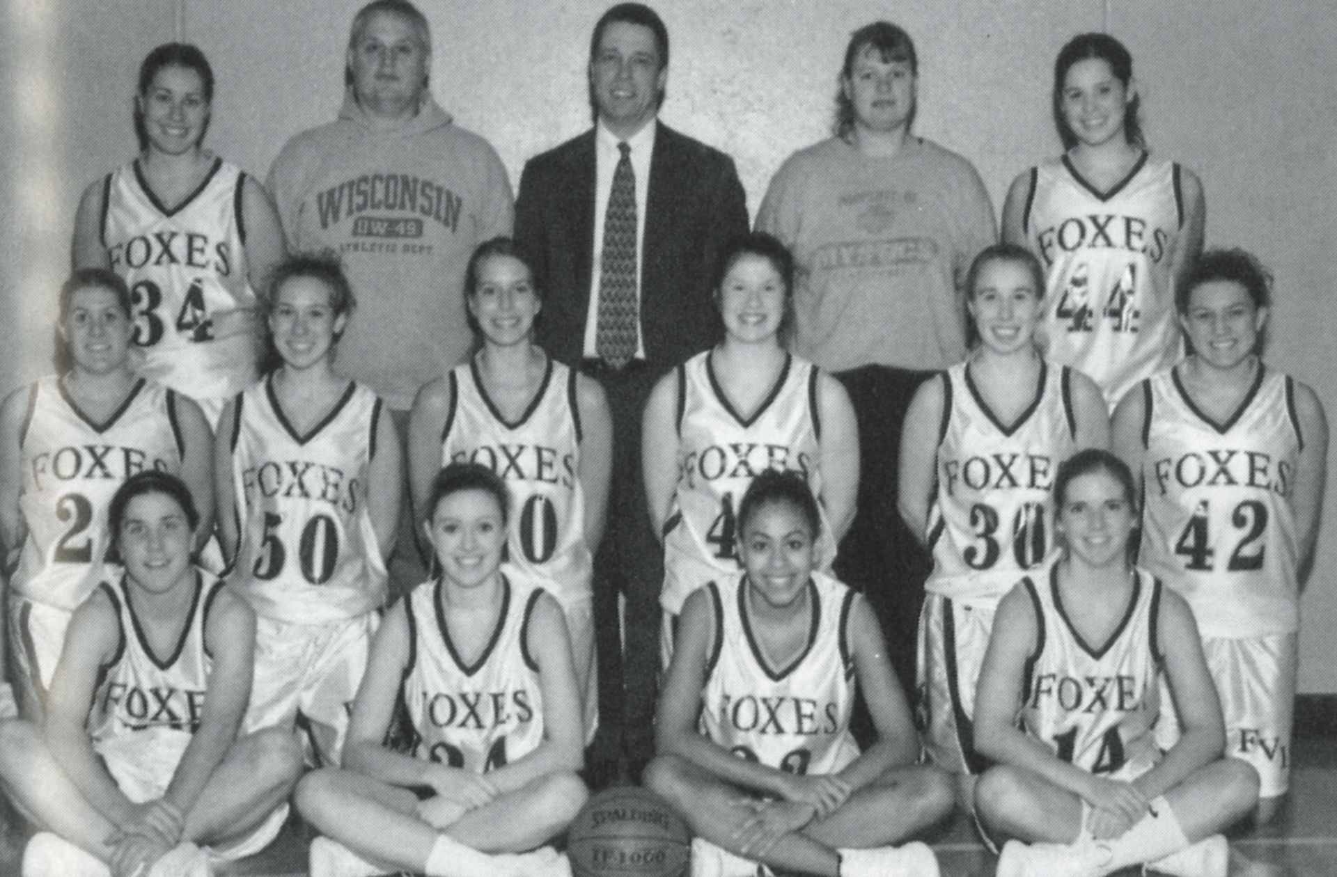 Female basketball team with coaches - smiling at camera