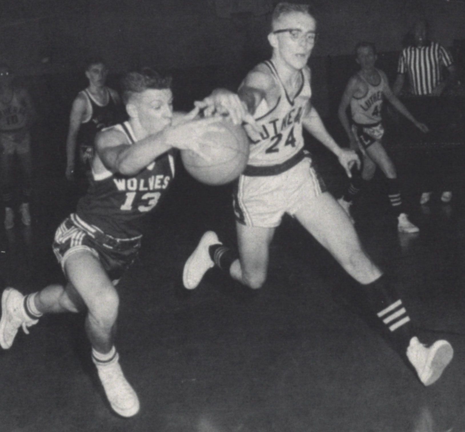 FVL boys basketball team member #24 trying to take the ball from dribbling opponent