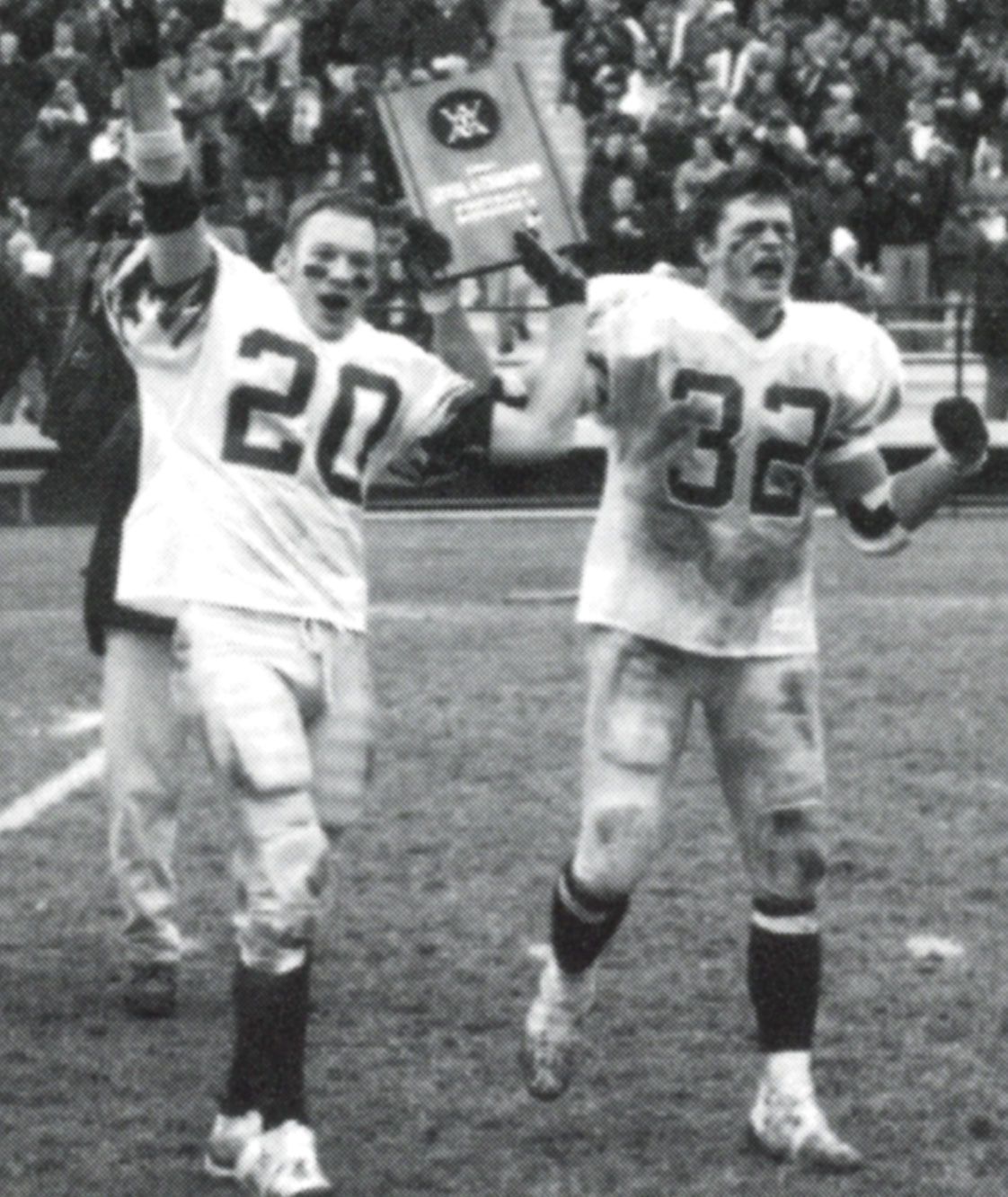 Two victorious team members holding WIAA plaque