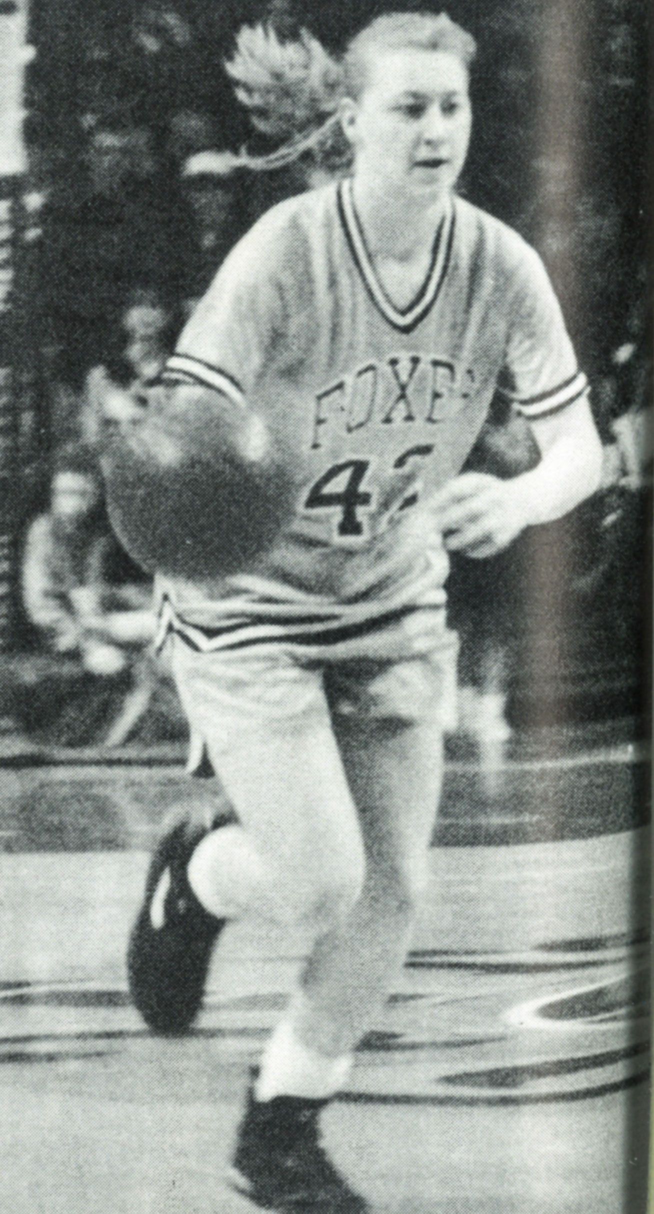 Female basketball team member dribbling down the court