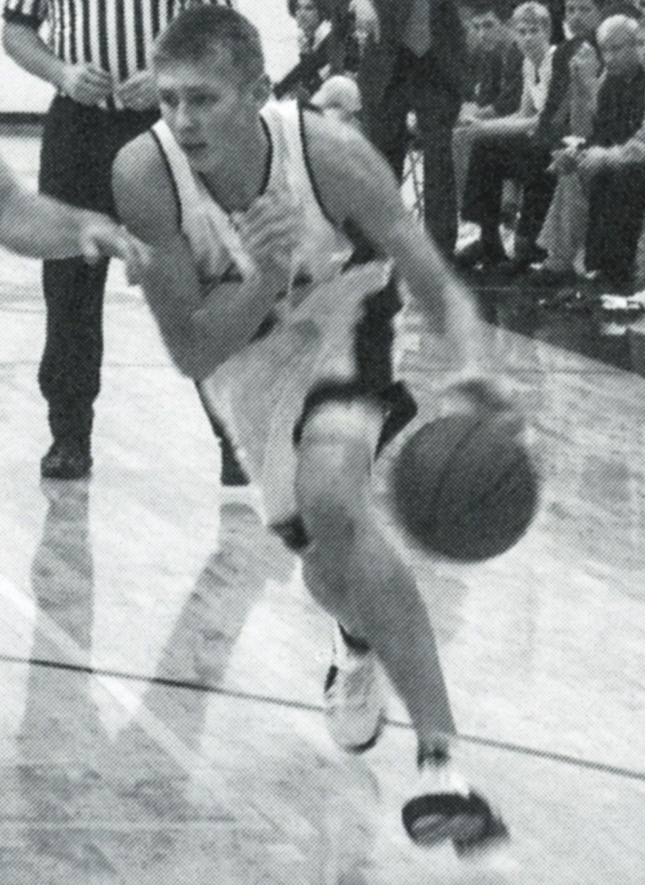 Male basketball player dribbling with opposition close