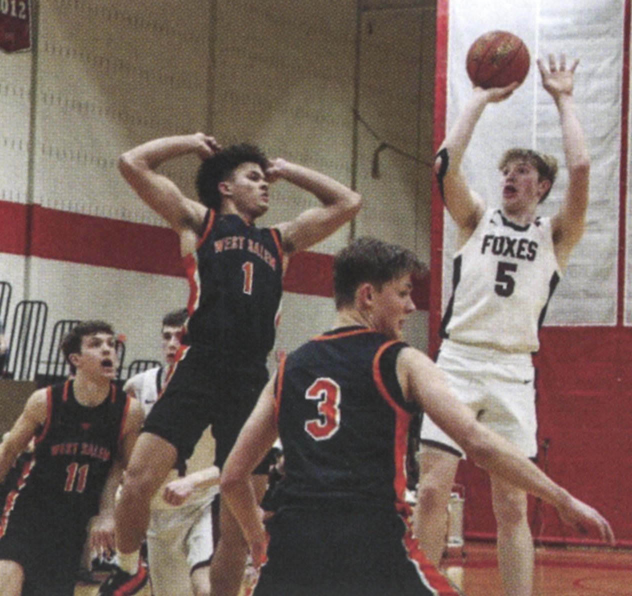 FVL boys team member in the air, shooting for a basket