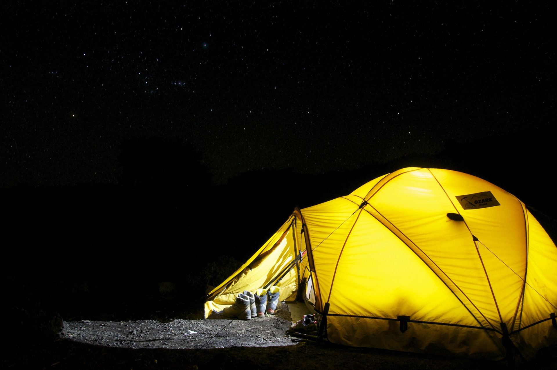 Yellow tent with light inside and with the night sky