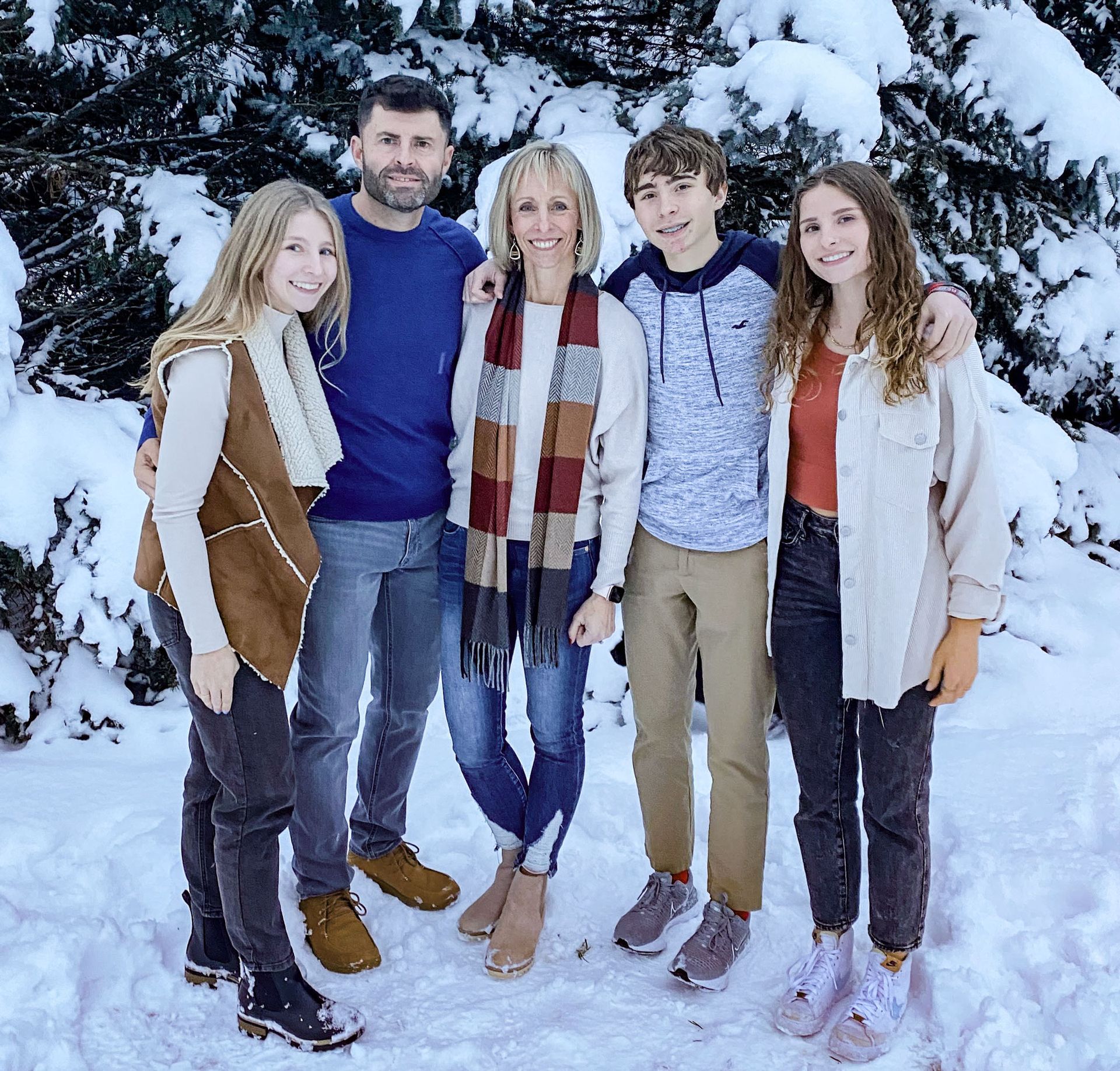 Family photo of the Wolfrath family standing in front of snowy trees