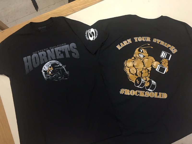 Black t-shirts with Hornets logo on front, muscular bee holding weights on the back, 