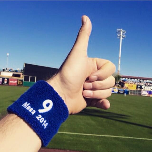 Hand with thumbs-up gesture, blue wristband with