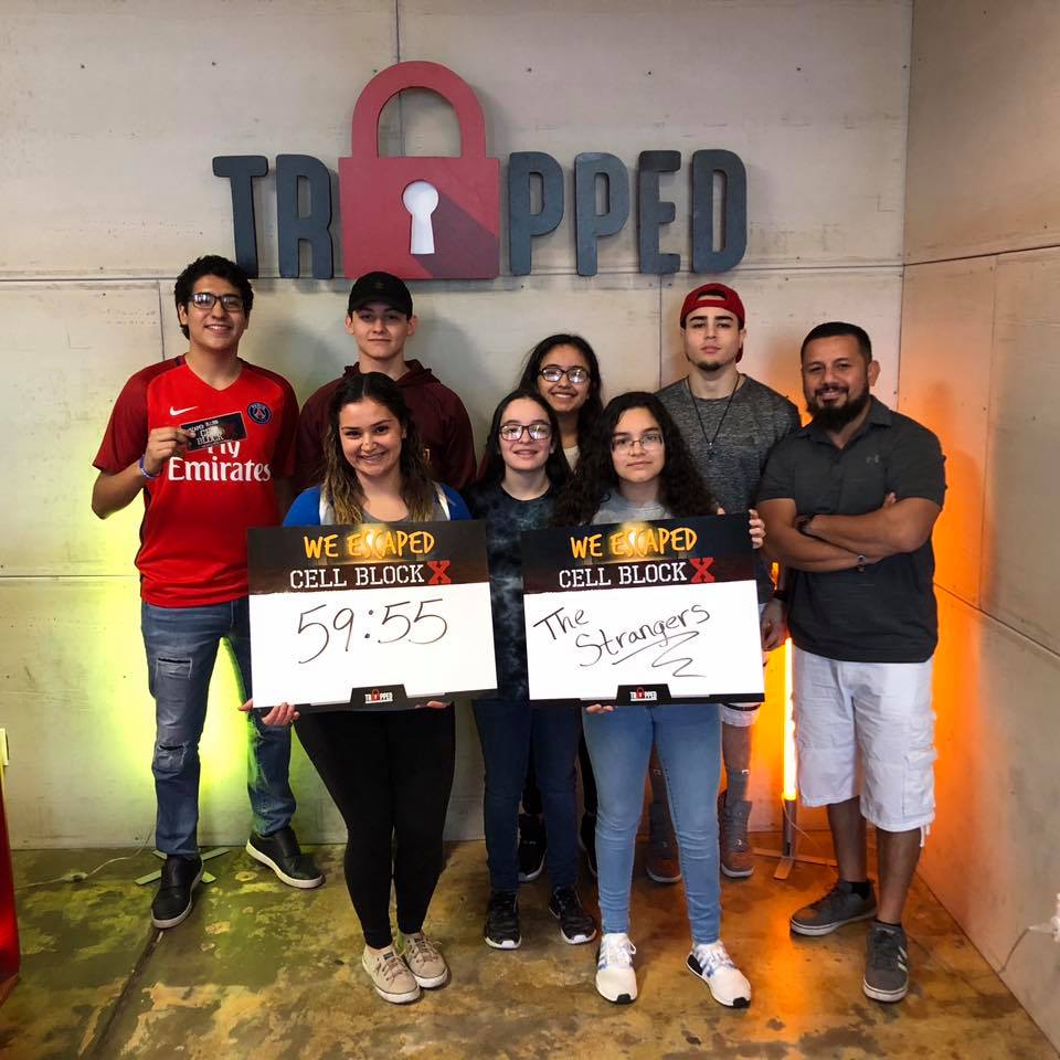A group of people standing in front of a sign that says trapped