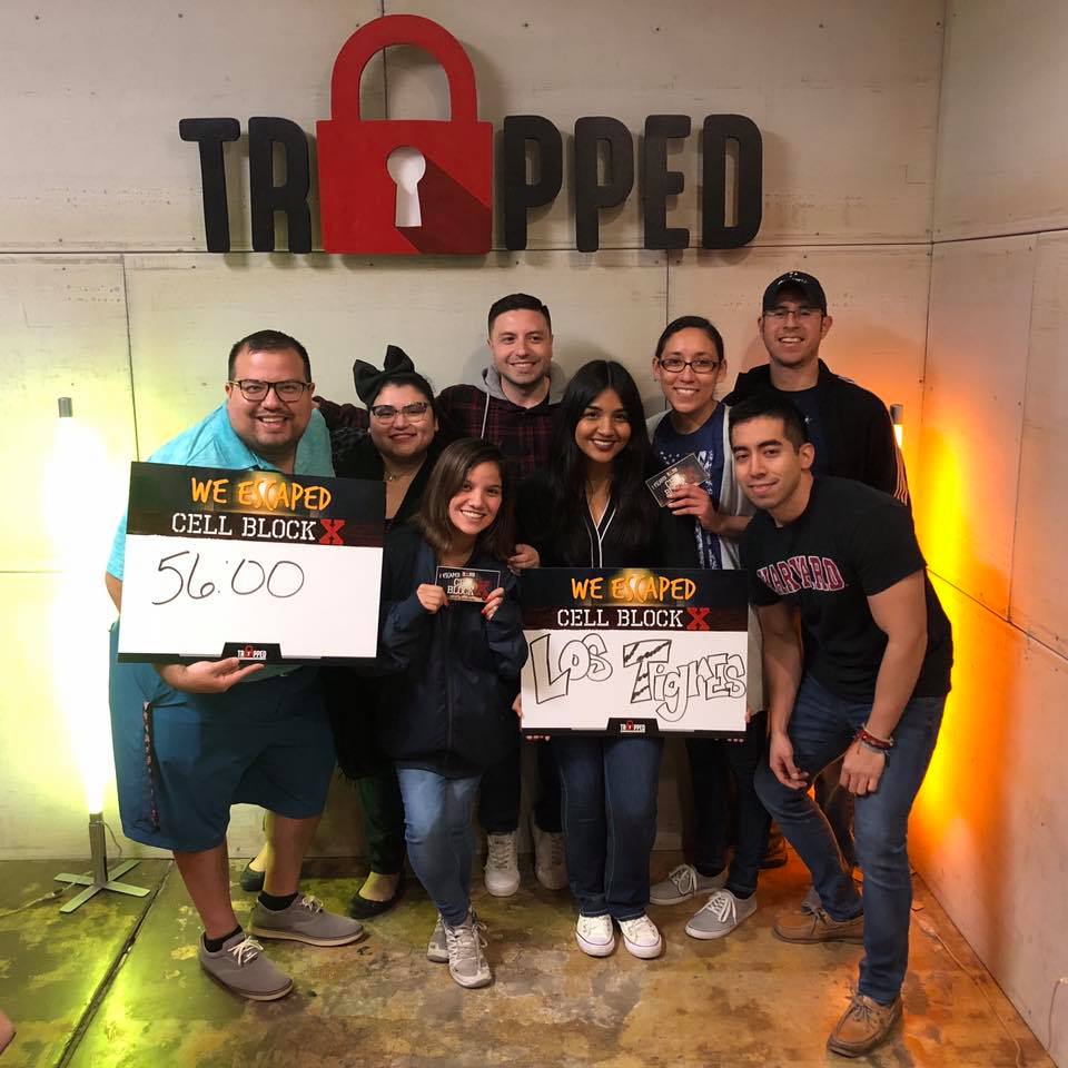 A group of people standing in front of a sign that says trapped