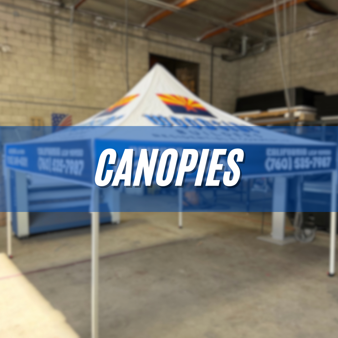 Blue canopy tent with white legs in an indoor warehouse, labeled “CANOPIES”