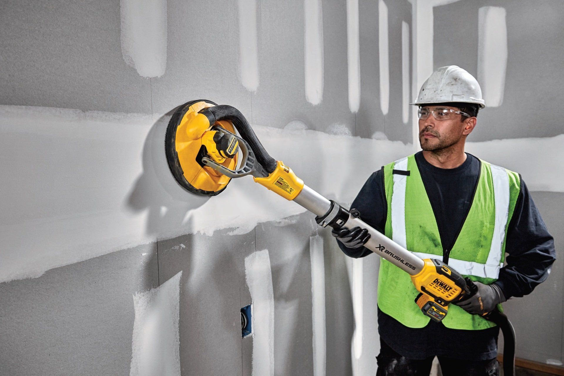 A contractor sanding drywall.