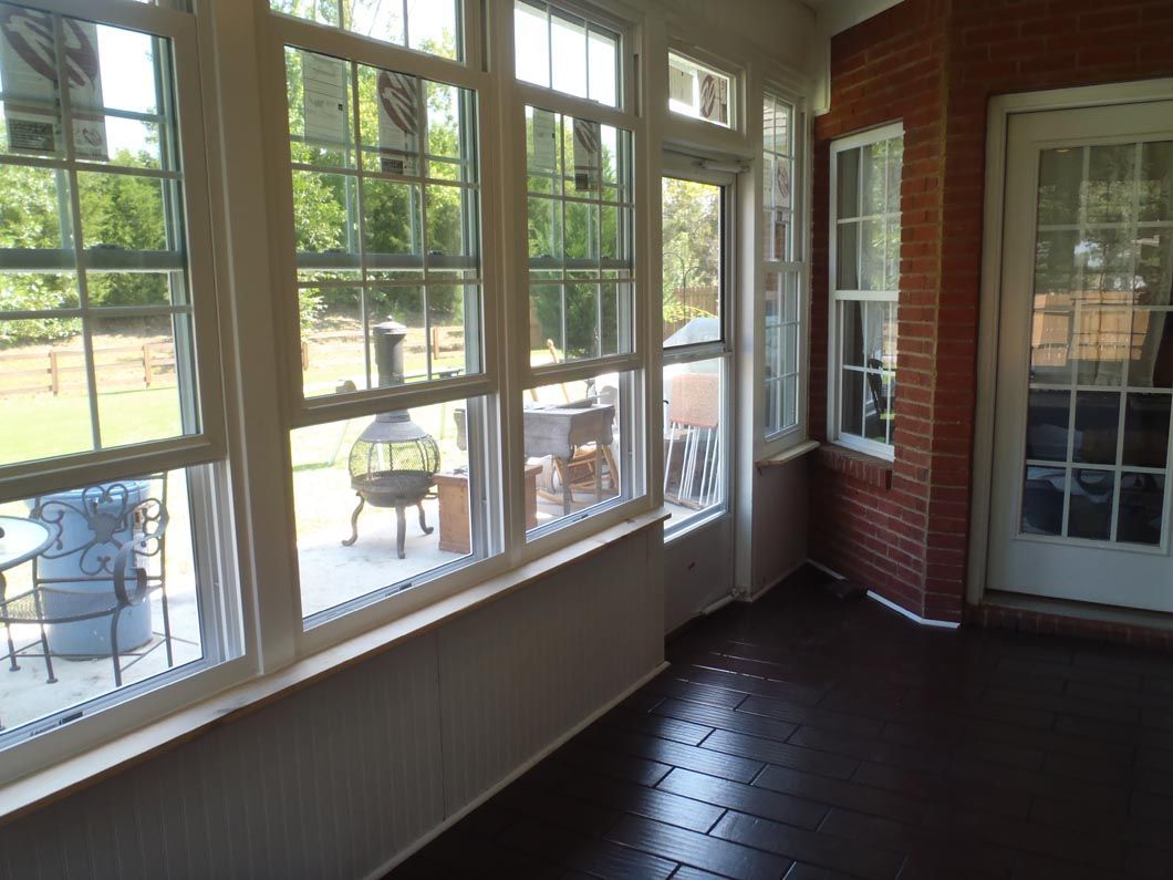 A sun room with lots of windows and a fireplace