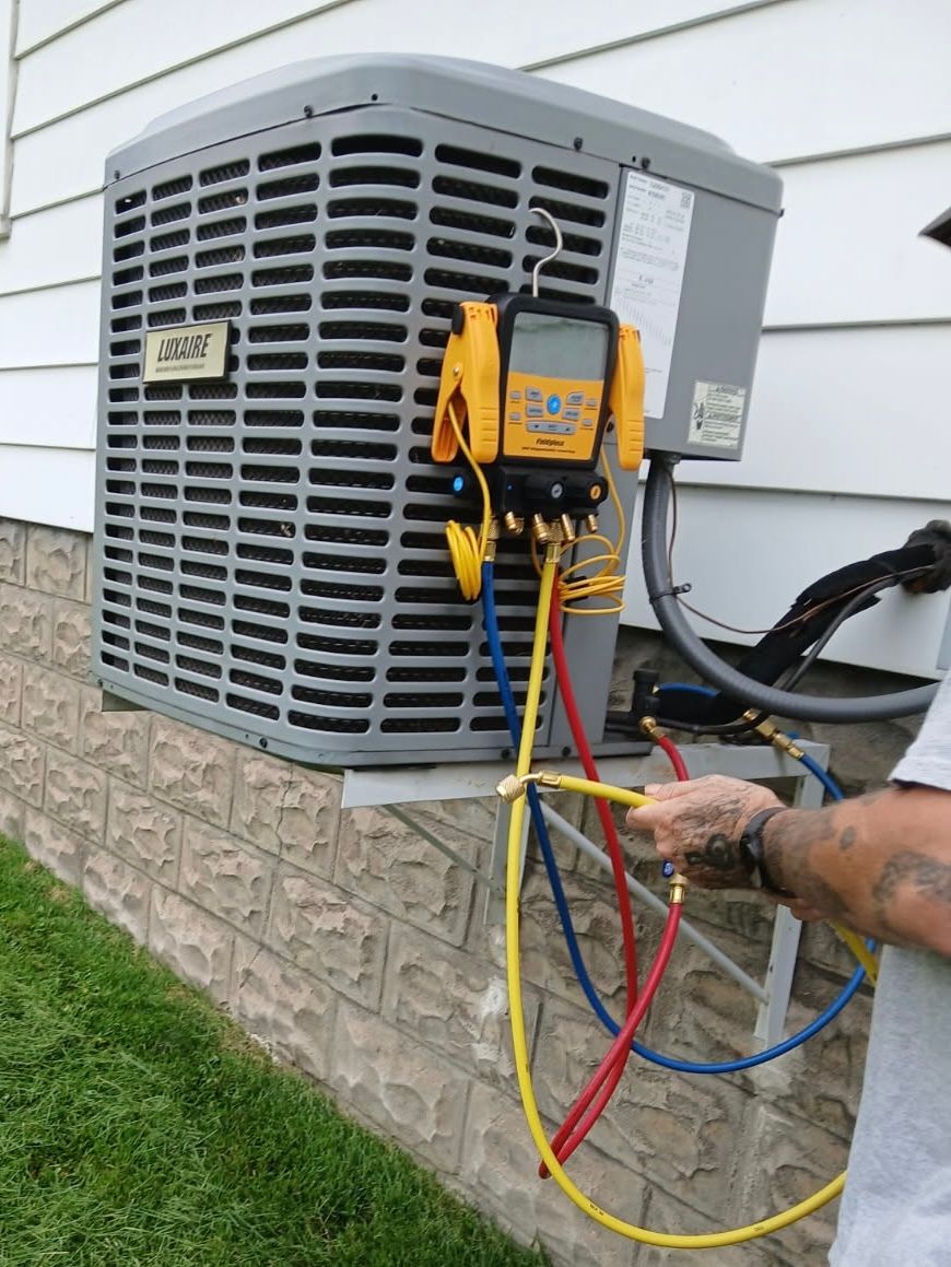 Serenity Home Services LLC - A man is working on an air conditioner outside of a house.