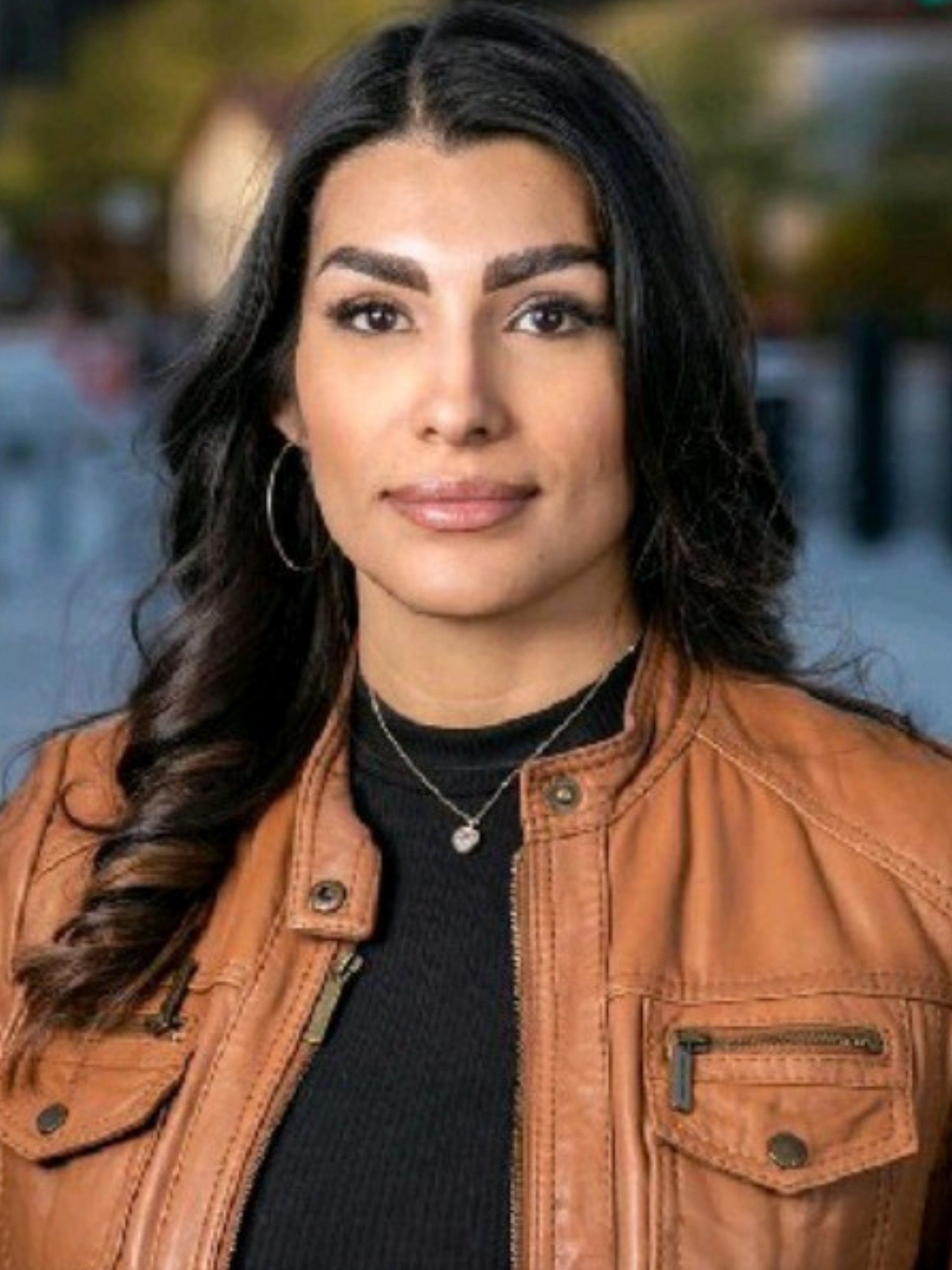 A woman in a purple shirt is smiling for the camera