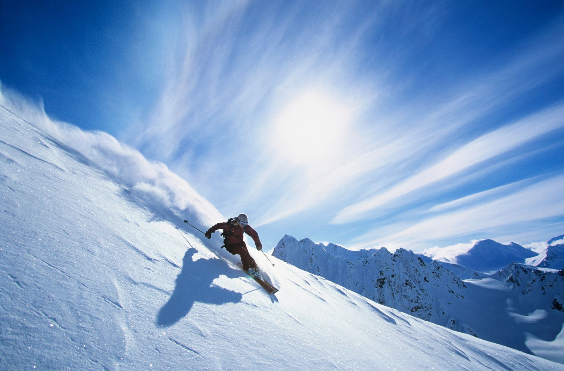 Una persona está esquiando por una montaña cubierta de nieve.