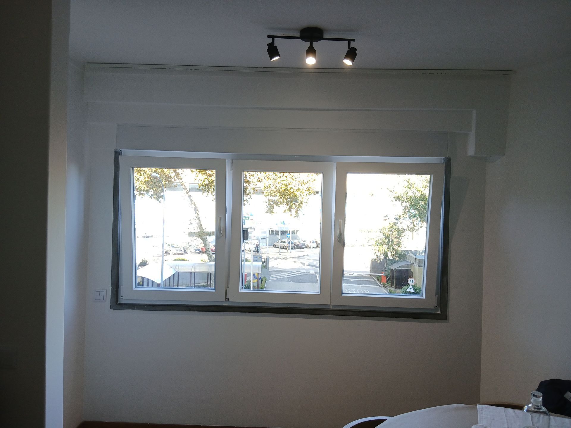 Vista interior de janela branca de três folhas com ferragens de segurança e vidro de alto desempenho.