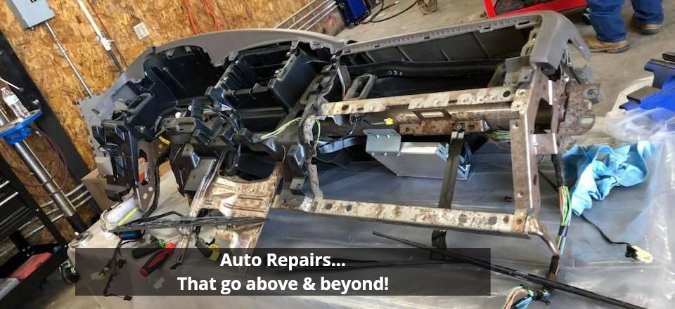 Car dashboard disassembled in auto repair shop. Interior frame and components visible.