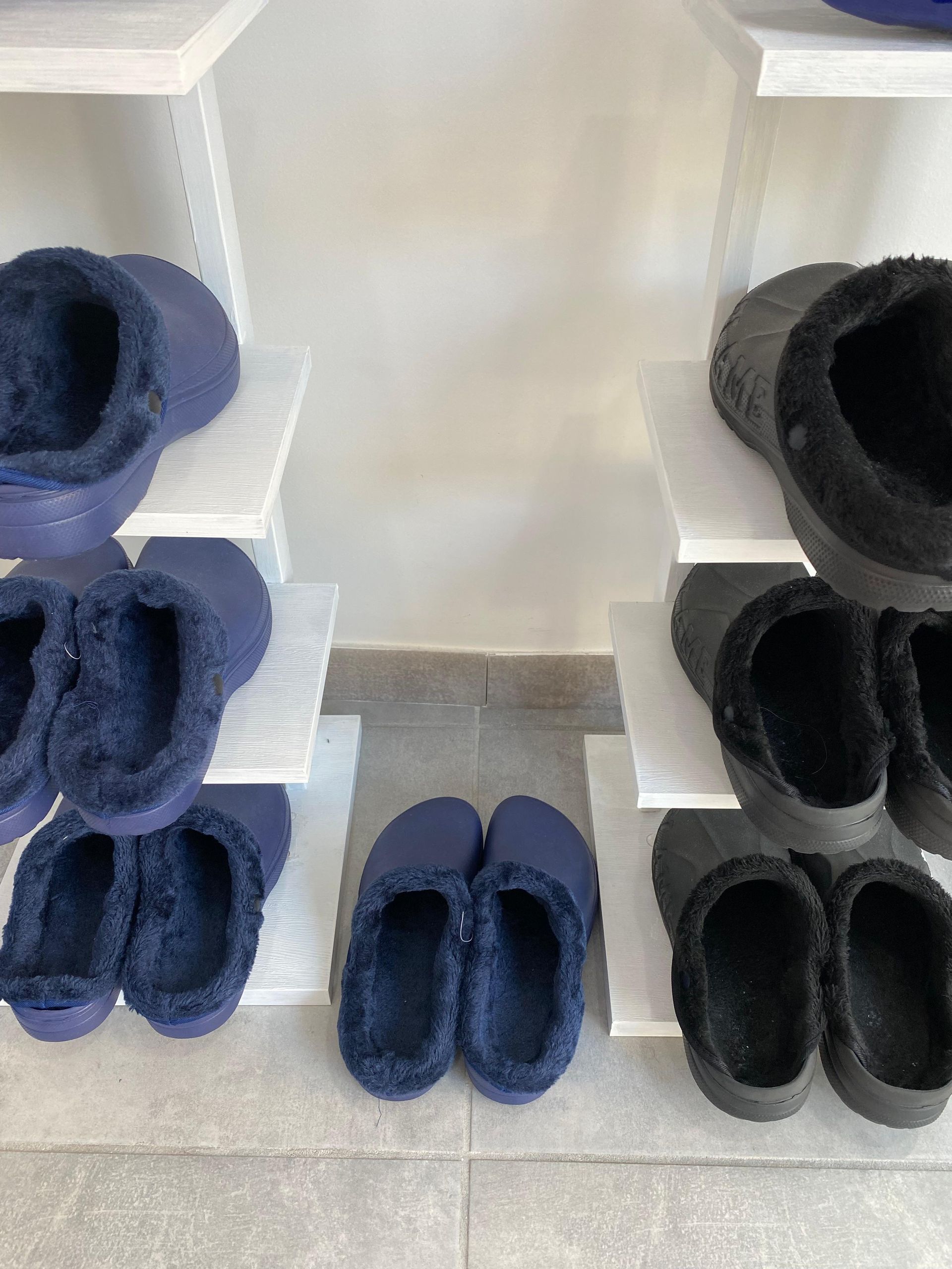 Una fila di pantofole sono allineate su uno scaffale